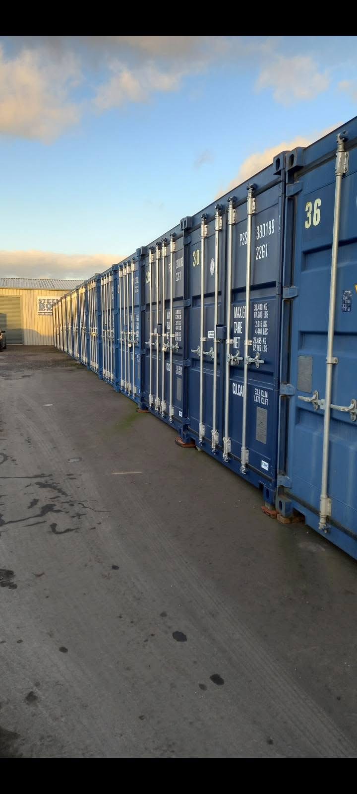 Long row of blue steel storage containers at the Larkhall yard